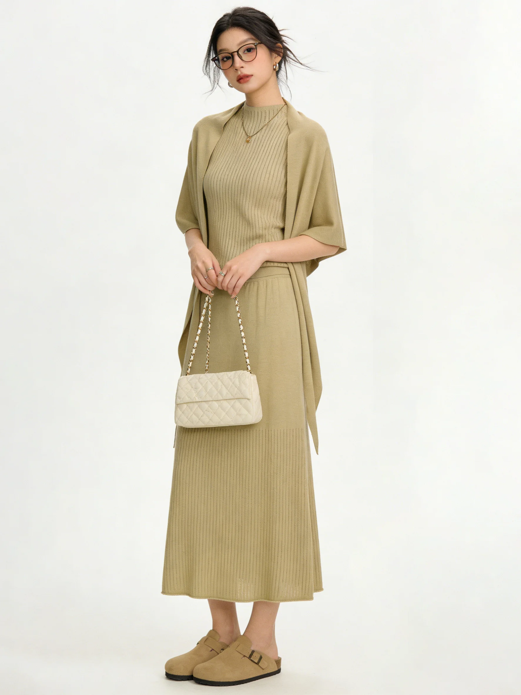 

Ретро-комплект из вязаного трикотажа: элегантный универсальный облегающий жилет без рукавов и юбка миди с высокой талией. Модный ансамбль Весна 2026.