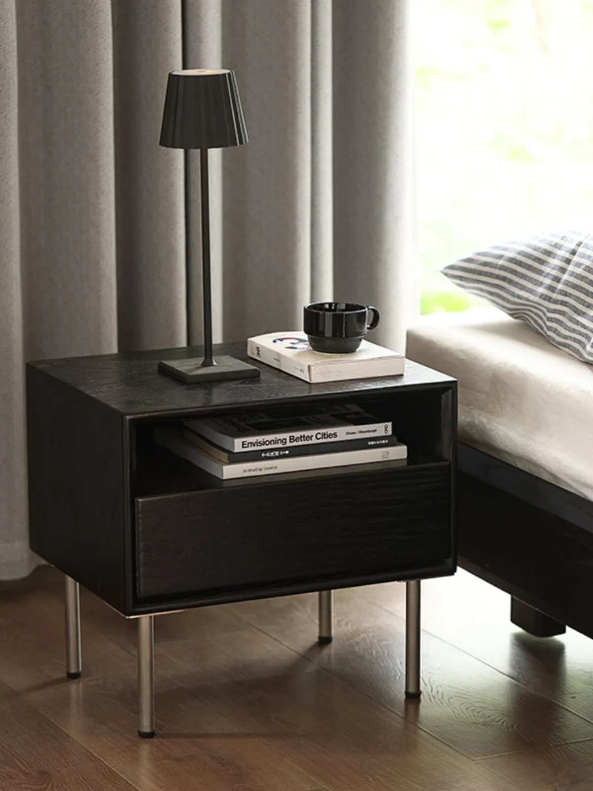 The bedroom bedside table is minimalist, modern and creative, with stainless steel legs and a black color scheme. The bedside image 4