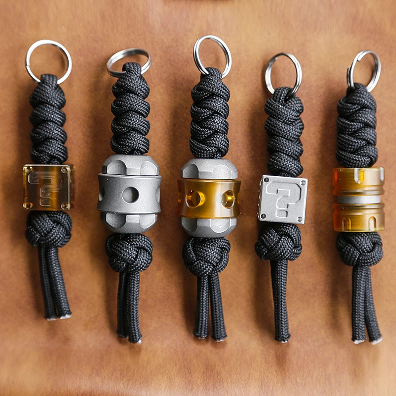 

New Titanium Alloy Outdoor Multifunctional Umbrella Rope Woven Key Pendant PEI Amber EDC Three in One Resin Pendant