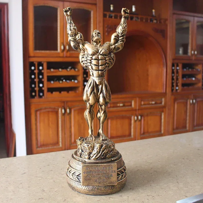 Fitness muscle man sets up bodybuilding sports competition trophies, boxing figures, statues, sculptures, gym decorations