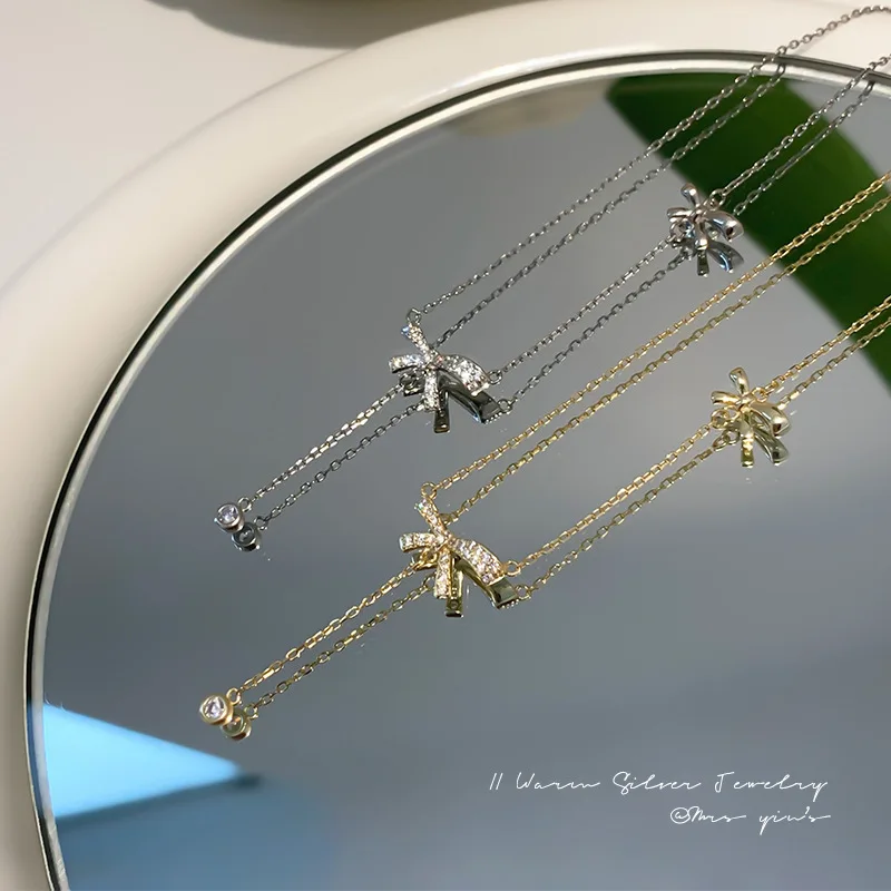 Bow-shaped pendant necklace crafted from 925 silver with copper clavicle chain — minimalist yet refined, elegant tassel detail,