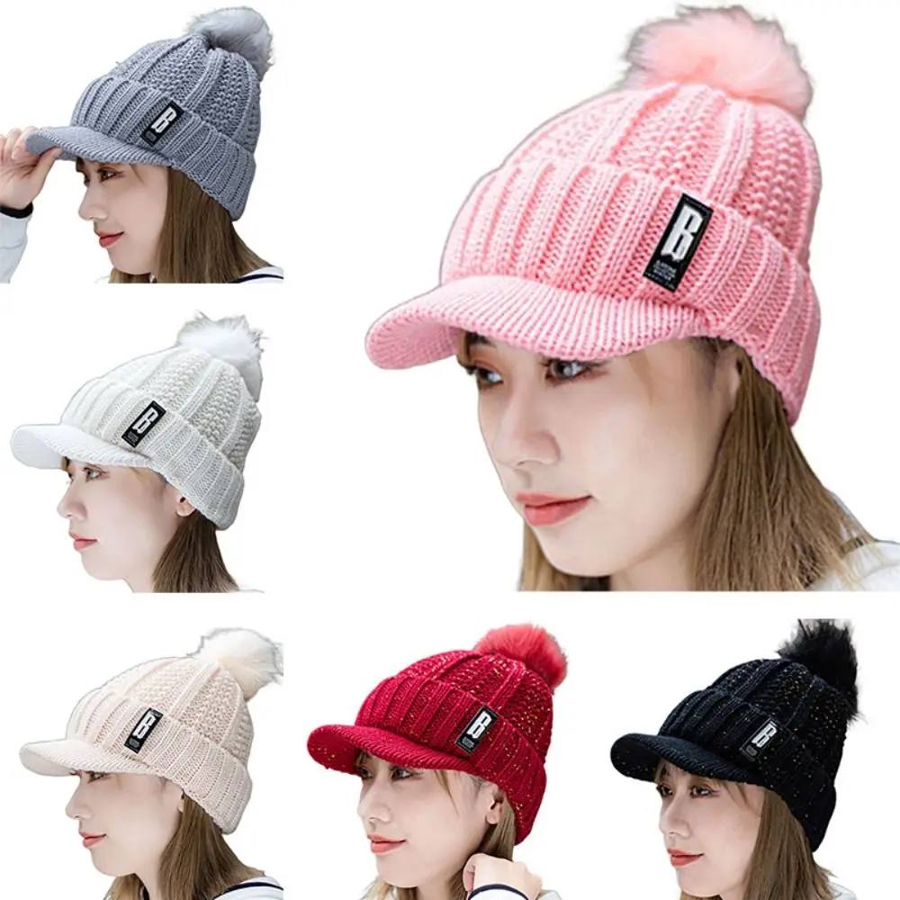 قبعة محبوكة عصرية دافئة سميكة مع كرات فرو قبعة شتوية مقاومة للرياح لحماية الأذن للنساء