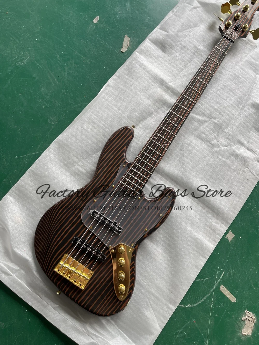 

Изготовленный на заказ 5-струнный бас из дерева зебры, корпус и гриф из зебры, фиксированный мост, акриловая защитная пластина, золотой тюнер, активный аккумулятор