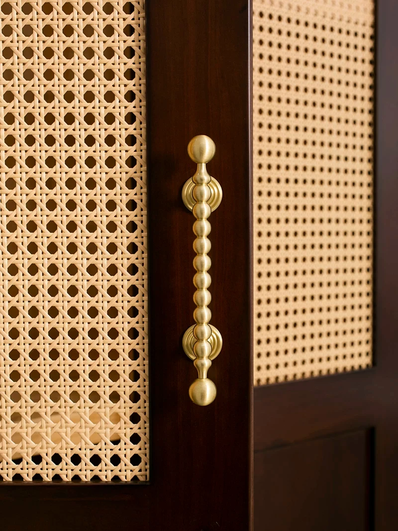 Close view of a beaded handle against woven cane panels