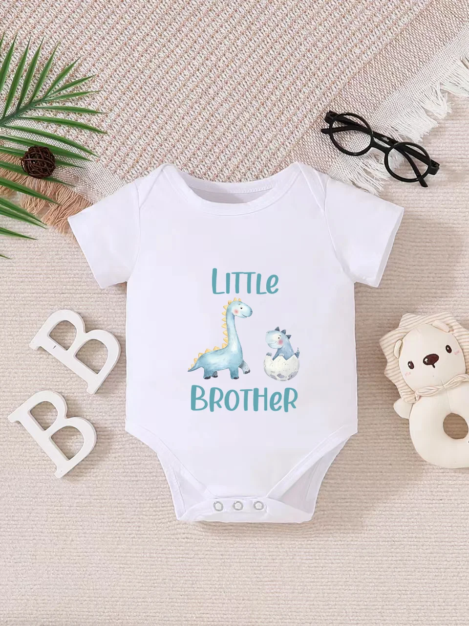 Playful letter-printed baby short-sleeve triangle bodysuit. Button closure for easy dressing, machine washable