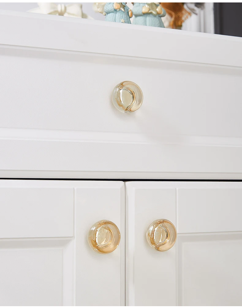 Oval champagne knobs fitted to white drawers and doors