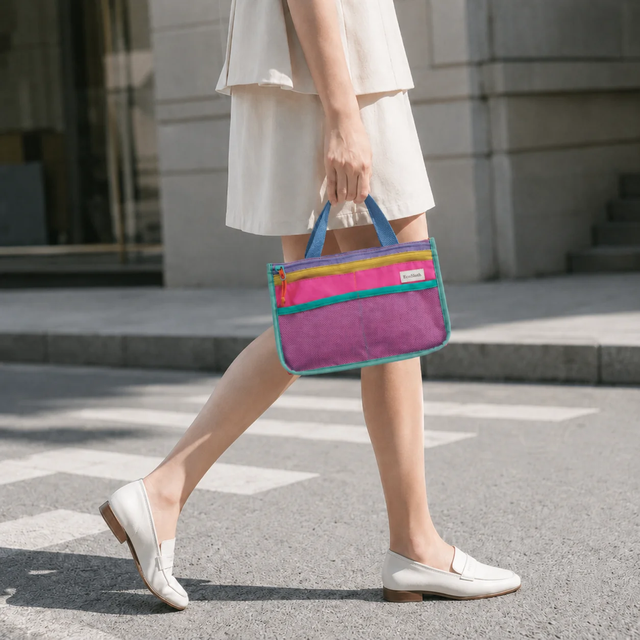 

EcoSloth tote bag, multi-colored striped patchwork, mesh outer pocket, internal compartments, a lightweight travel organizer.