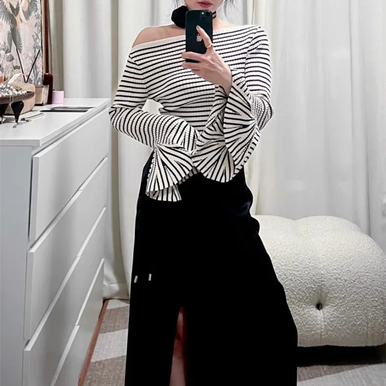 เสื้อถักไหมพรมสไตล์ยุโรประดับไฮเอนด์ ดีไซน์เปิดไหล่ข้างเดียว ลายทางสีขาวดำ แขนทรงกระดิ่ง ช่วงเอวไม่สมมาตร สำหรับผู้หญิง...