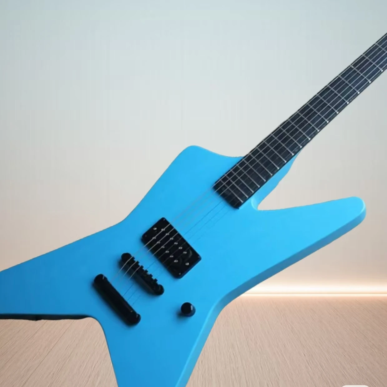

The 6-string blue electric guitar has a specially shaped body, black hardware, and no Fret inlays