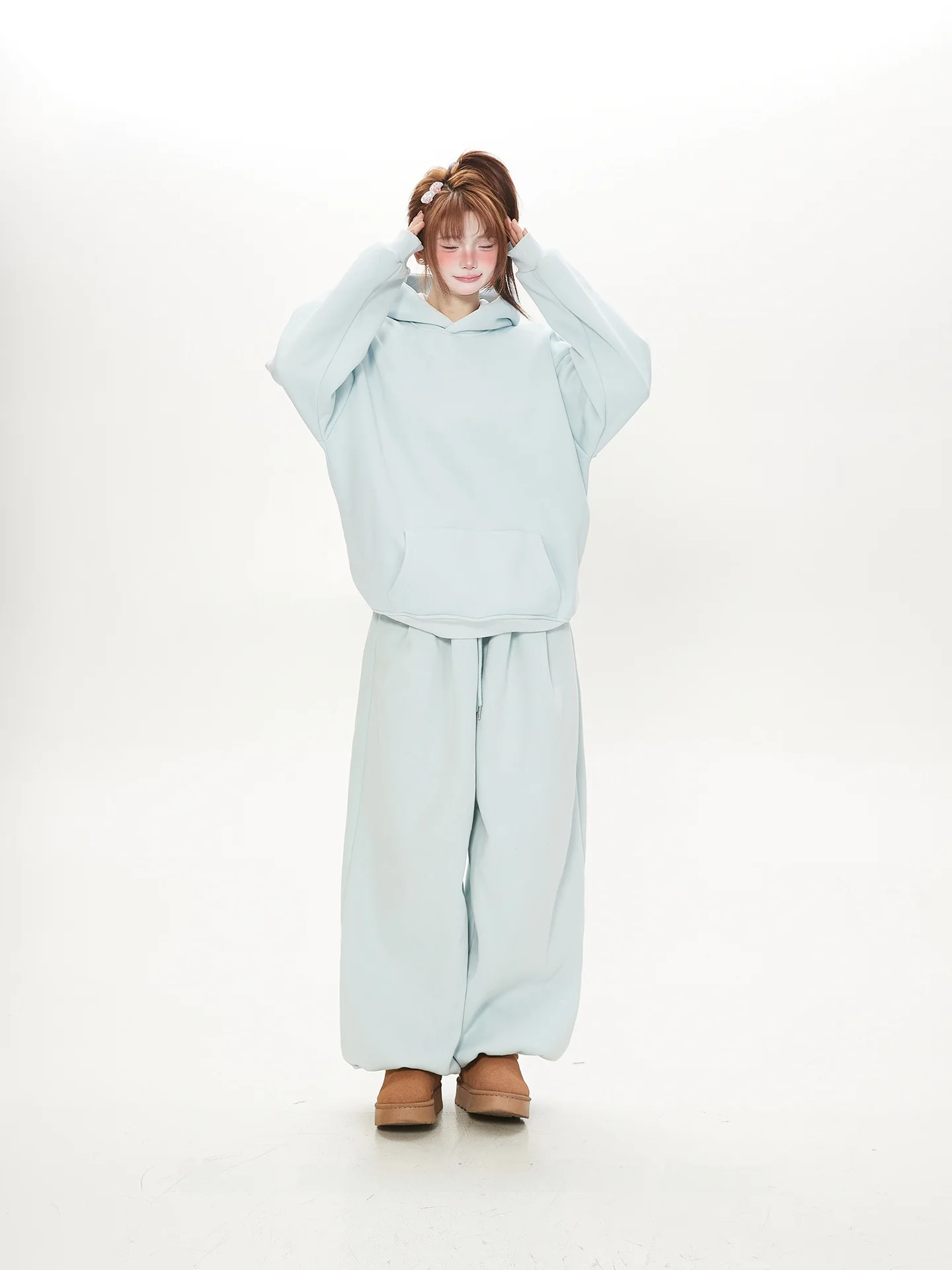 

Комплект из двух предметов: светло-голубая толстовка и свободные брюки для женщин. Красивый повседневный костюм для весны и осени.