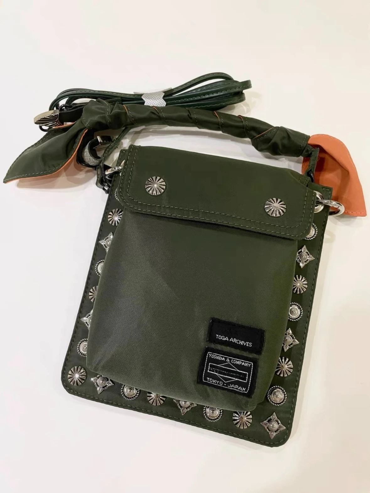 

Портативная сумка-мессенджер Port Yoshida с ретро-дизайном, квадратной формой и декоративными заклепками.