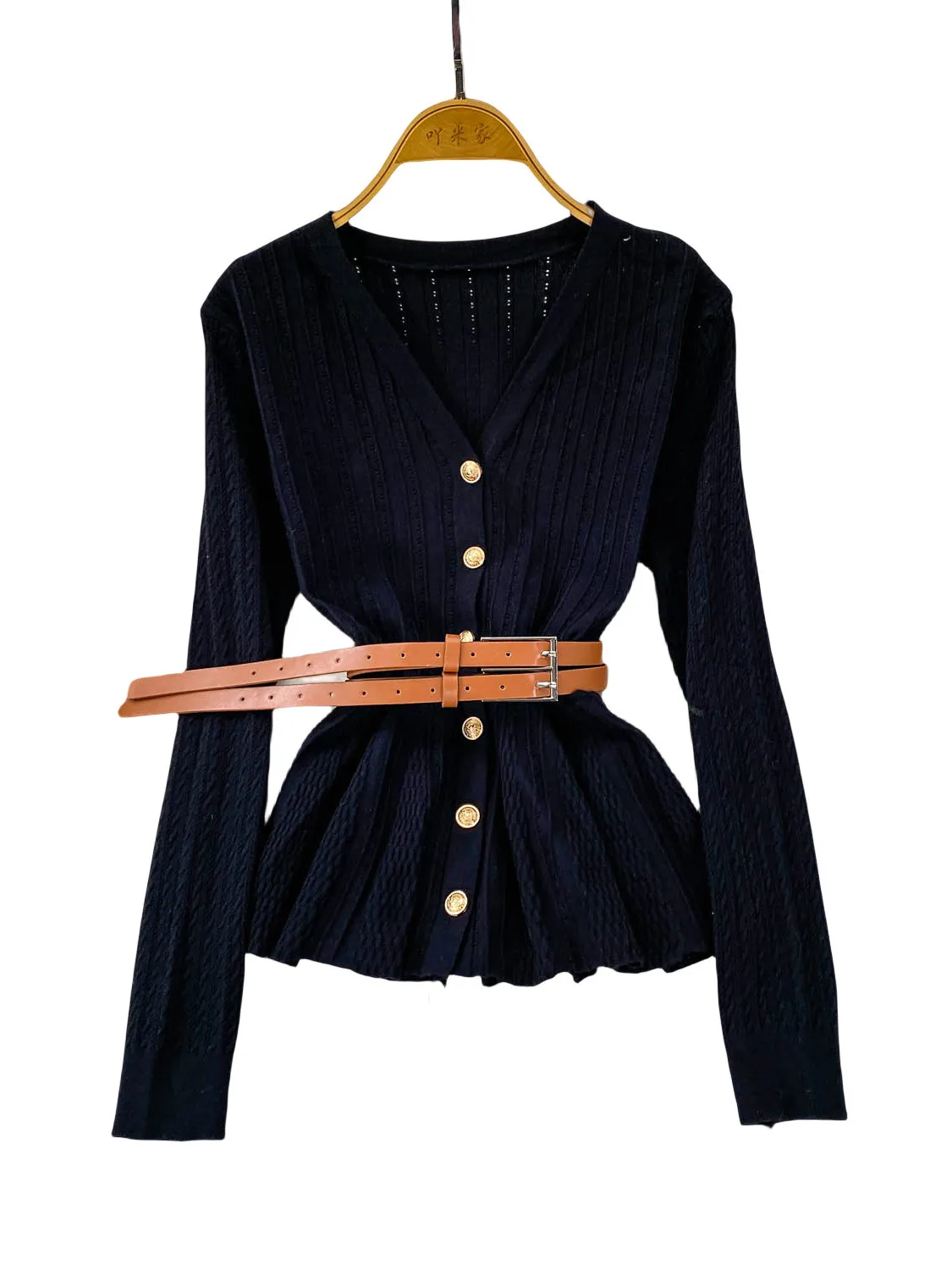 Niebieska dzianinowa bluzka z dekoltem w serek, długim rękawem, ażurowym wzorem, damska, jesienna, elegancka, z paskiem w talii, metalowa, niebieska, delikatny wiatr.