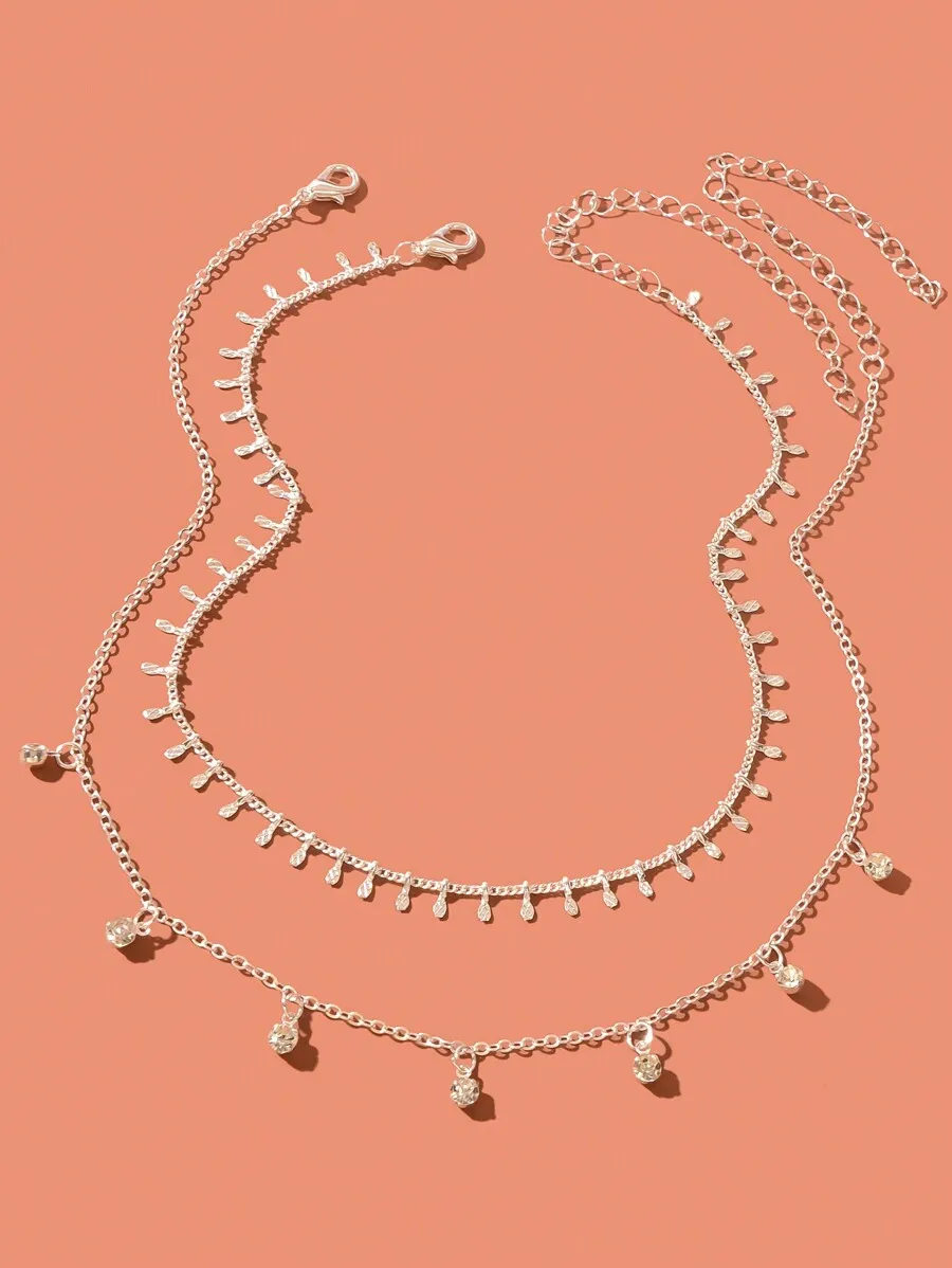 

Набор из двух многослойных серебристых ожерелий-чокеров с кристаллическими подвесками