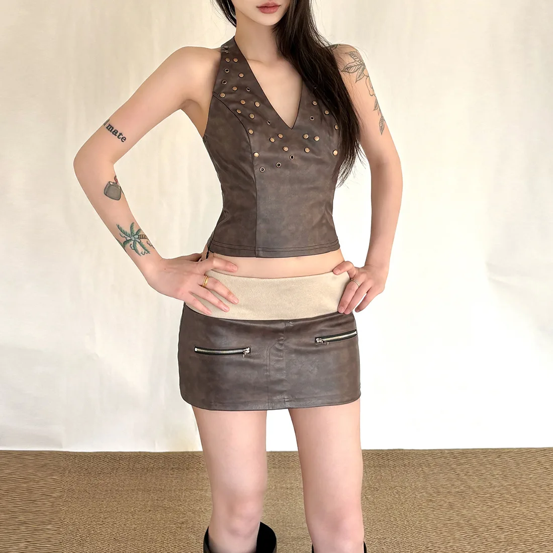 

Модный комплект из двух предметов: укороченный топ-халтер и мини-юбка из искусственной кожи. Горячая новинка для уличного стиля.