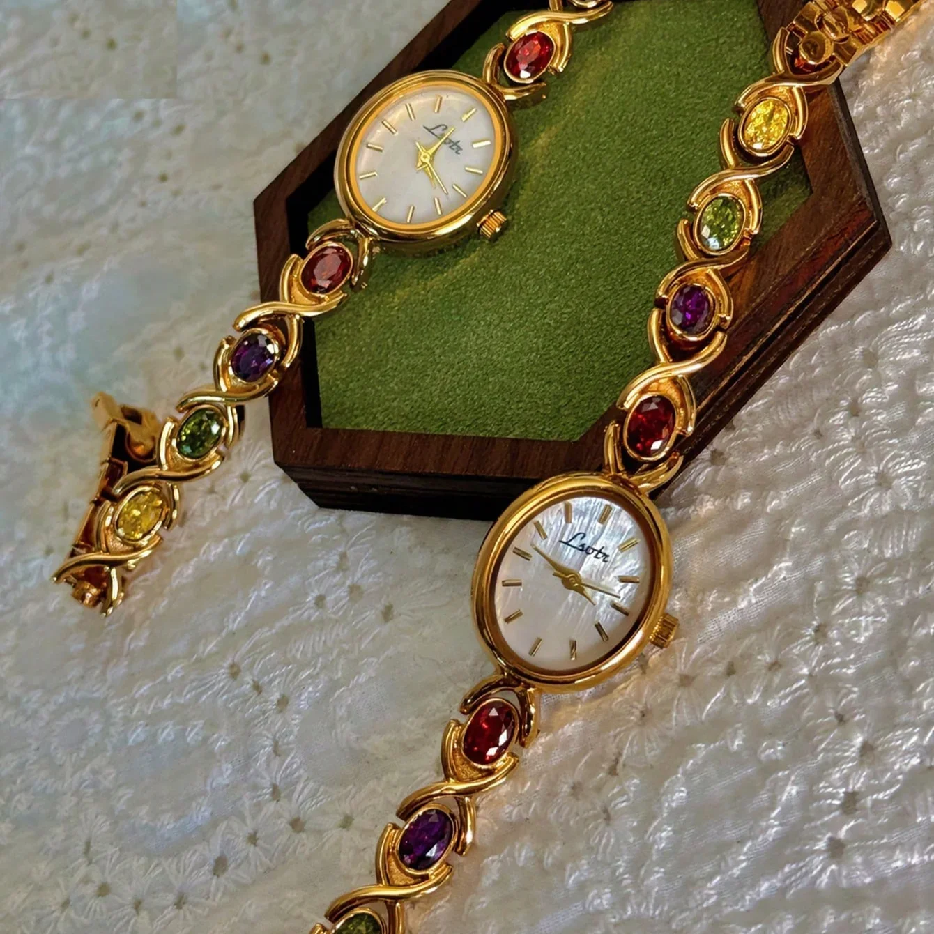 A lady\'s watch with colorful tourmaline, diamond and oval mother\'s pearl dial.