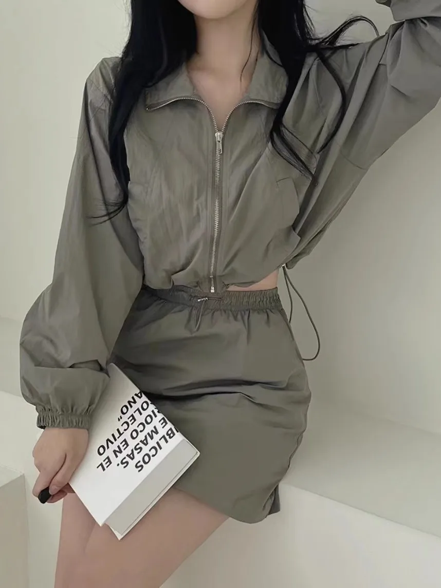 

Женский комплект: ветровка с длинными рукавами и складками, а также юбка с эластичным поясом на шнурке для коррекции фигуры