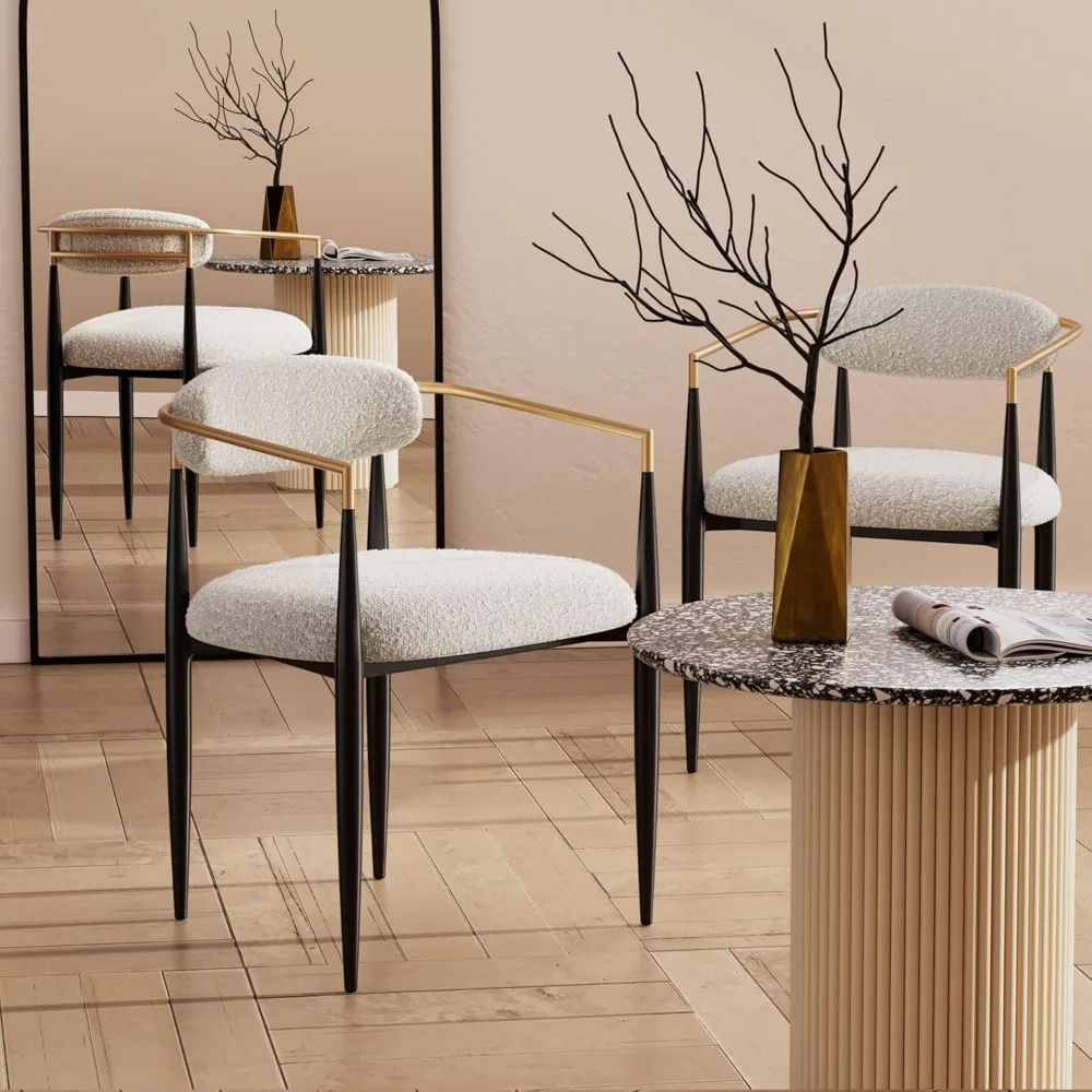 زوج من كراسي تناول الطعام المنجدة الحديثة مع مساند للذراعين ذهبية وأرجل معدنية سوداء، مثالية للجلوس المميز