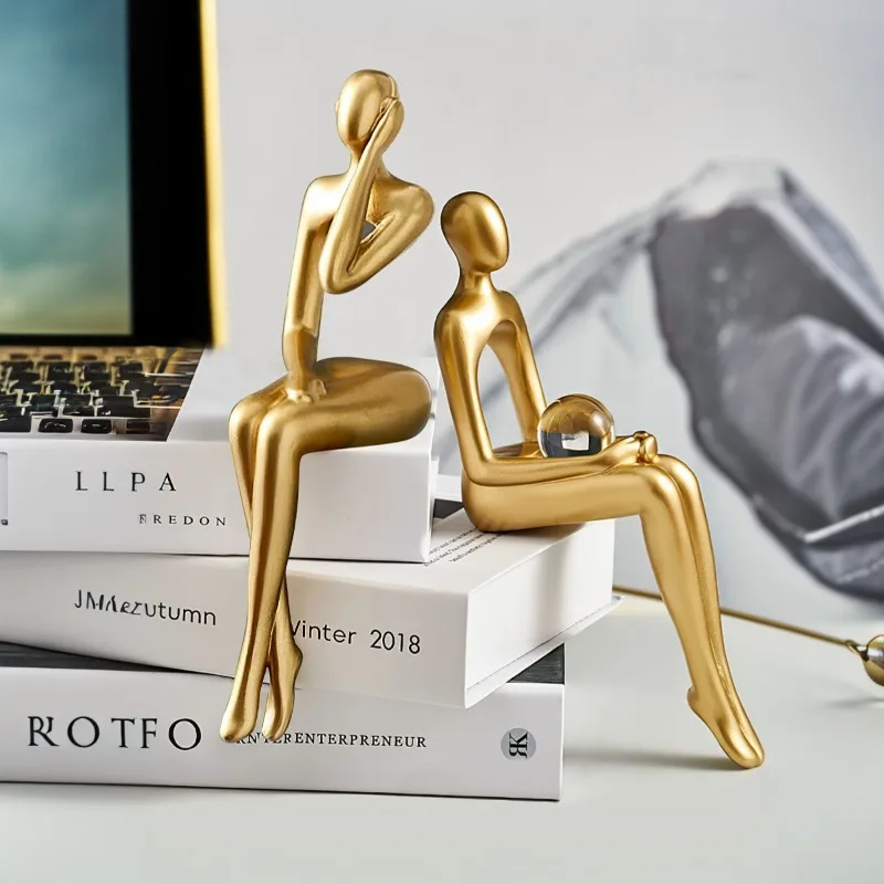 Simple little golden man holding a ball and listening to music, gold abstract figure sculpture home decoration office
