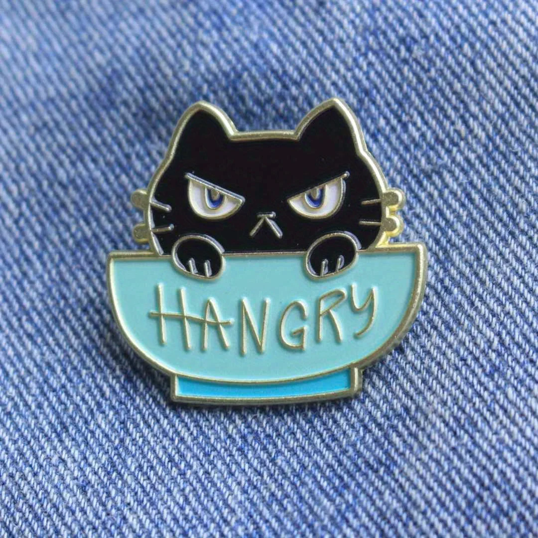 دبوس المينا للقطط الغاضبة - تصميم قطة كرتونية باللونين الأزرق والأبيض مع نص "HANGRY".