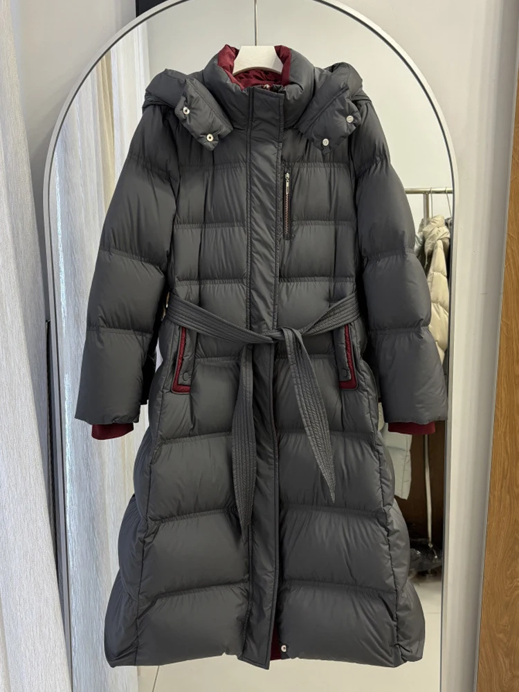 Elegant Long down jacket with hooded women's 2026 Winter High quality warm puffer coat with sashes Female outwear INKEO DJ640