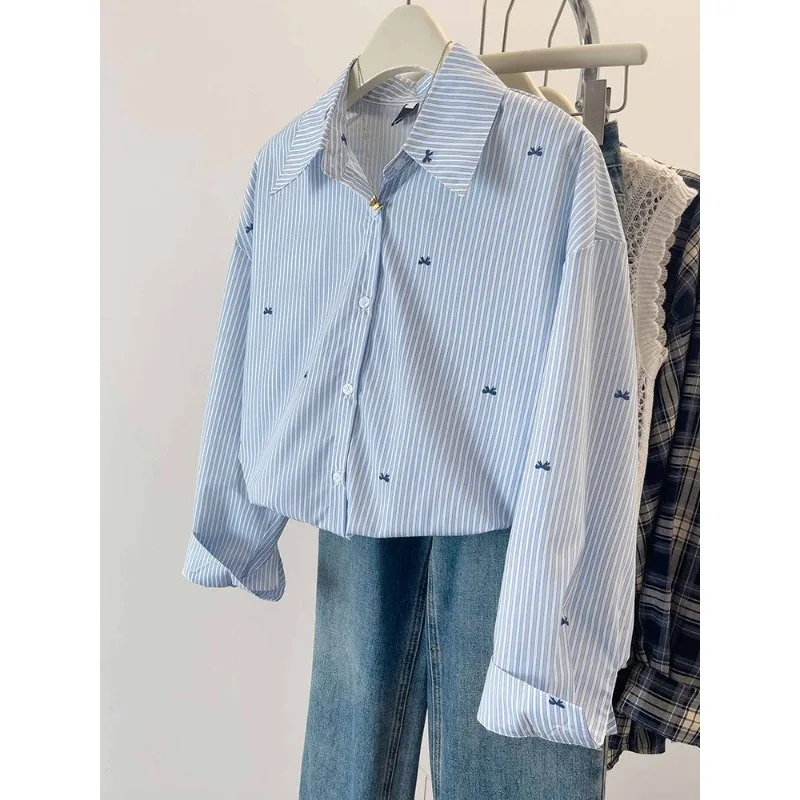 เสื้อเชิ้ตลายทางสีฟ้า เสื้อเชิ้ตแขนยาวพิมพ์ลายโบว์สไตล์เกาหลีลำลองสำหรับผู้หญิง