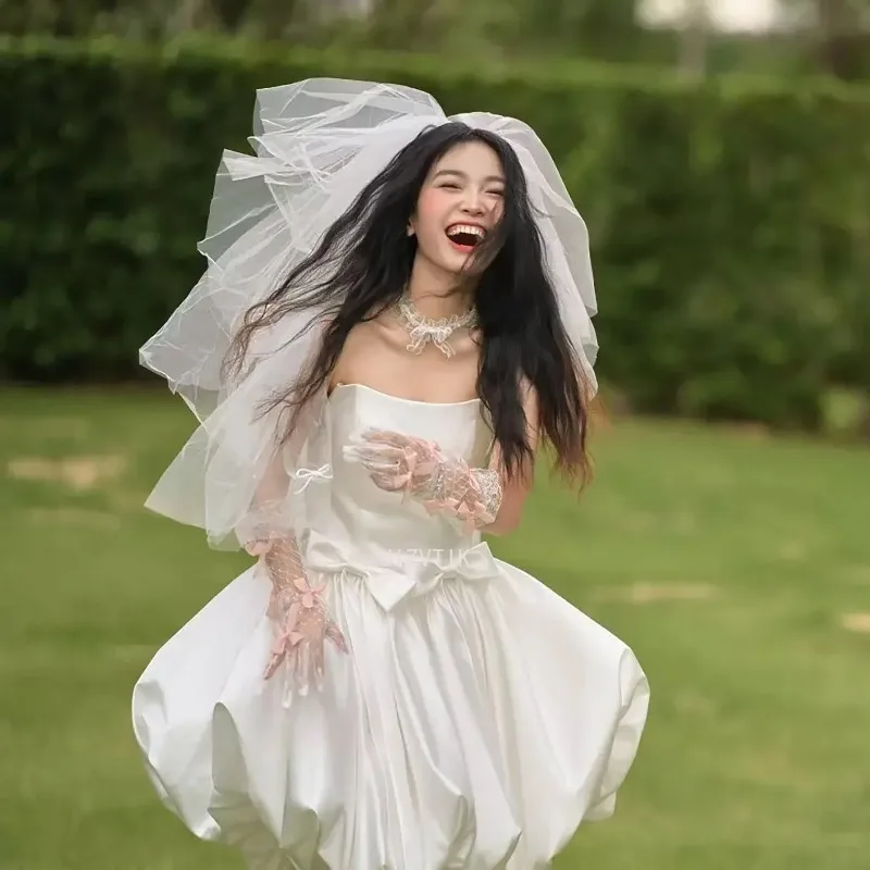 فستان زفاف قصير بسيط بيج بدون حمالات على شكل حرف a من الساتان بفيونكة قصيرة كورية لالتقاط الصور فستان زفاف مخصص للحفلات وأعياد الميلاد