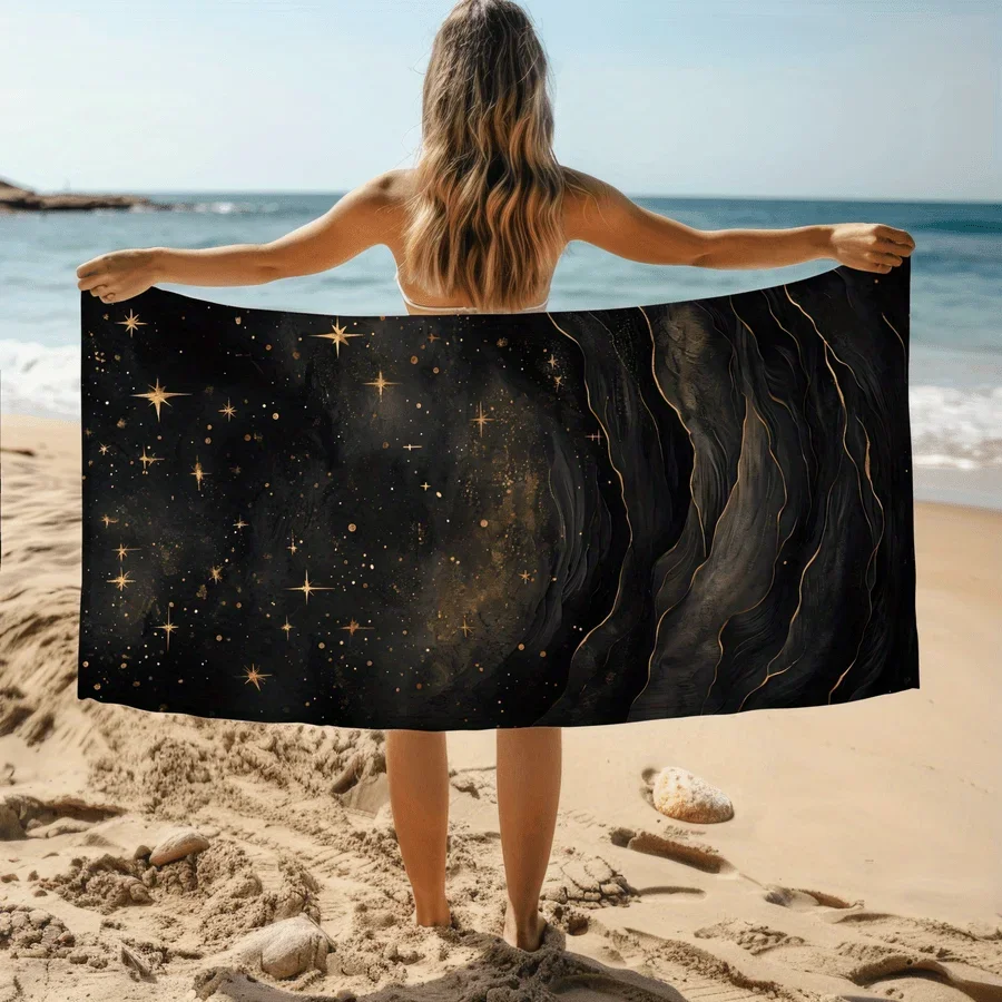 Black and gold starry sky and galaxy patterned beach towel, made of polyester, machine washable, perfect for travel and pool use