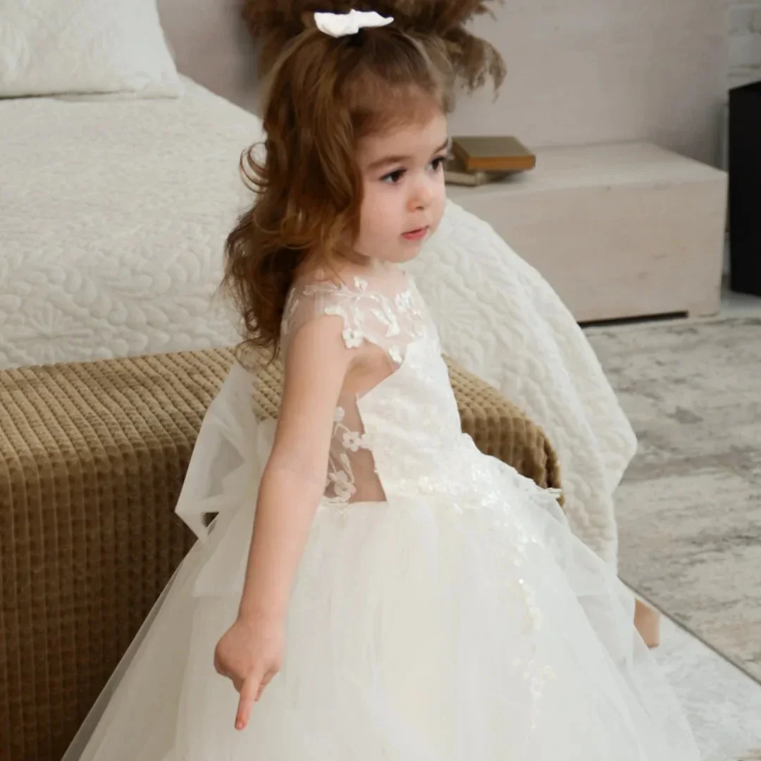 فستان فتاة الزهور البيضاء المخصص من التول مزين بالزهور مع فيونكة بدون أكمام لحفلات الزفاف وأعياد الميلاد وحفلات التواصل المقدس
