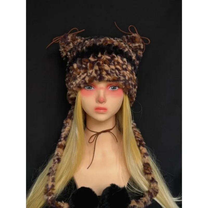 Een handgemaakte winter- en herfstwarme, katvormige oorbeschermers, gemaakt van gebreid pluche garen.