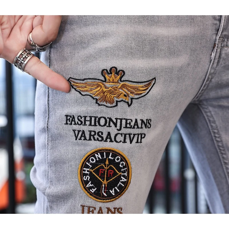 Street personality embroidery letters badge denim pants summer hole men's jeans light luxury fashion slim stretch pencil pants