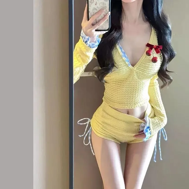 

Женский комплект бикини из двух частей: синий топ-халтер в клетку и желтые текстурированные шорты с завязками по бокам.