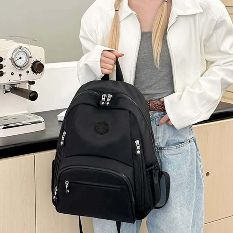 حقيبة ظهر للسفر للرجال والنساء ذات طراز محايد باللون الأسود بسعة كبيرة. تصميم بسيط، مناسب للحقائب المدرسية.