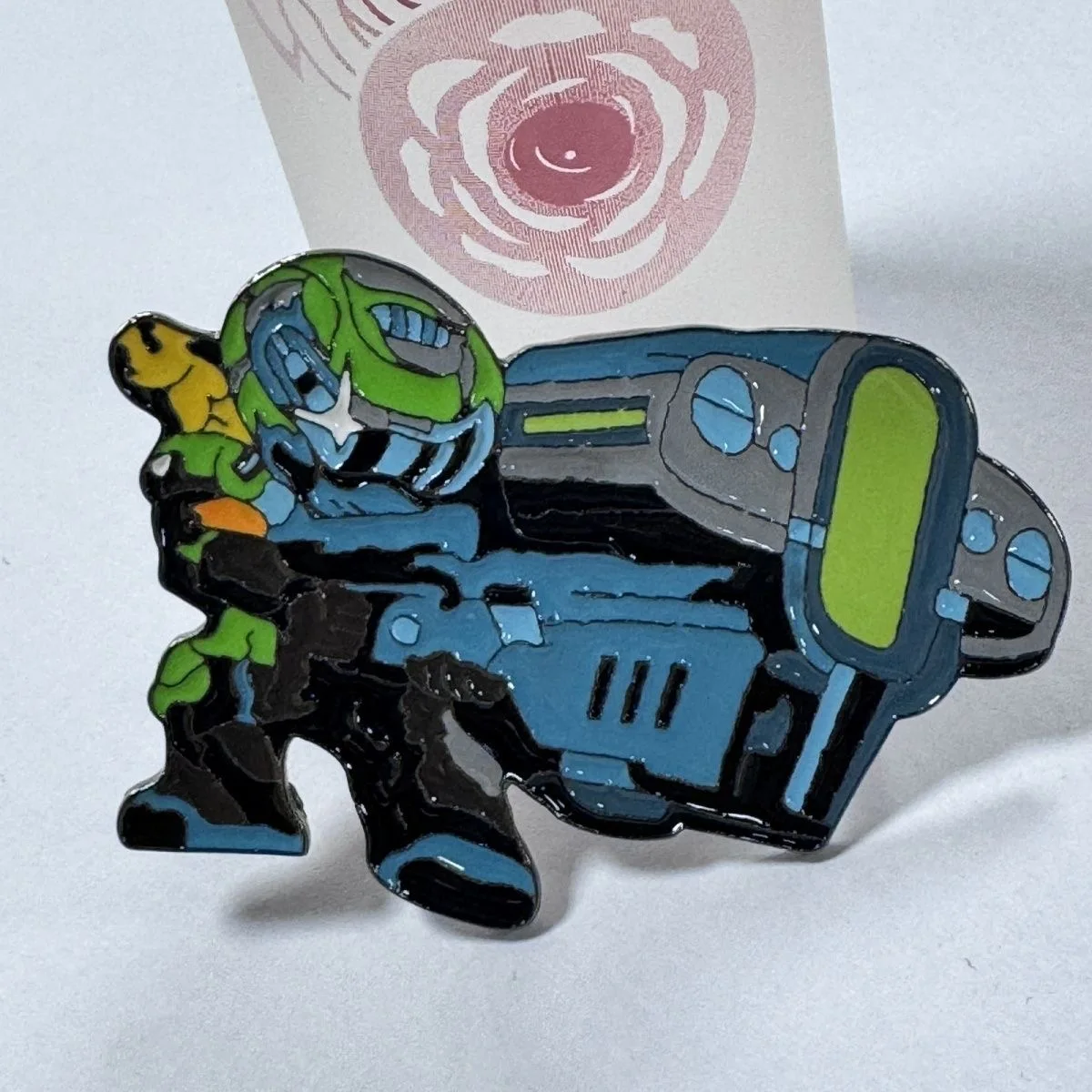 Cool enamel pin of a sci - fi warrior wielding a giant weapon. Vibrant colors, unique design. A must - have for genre fans.