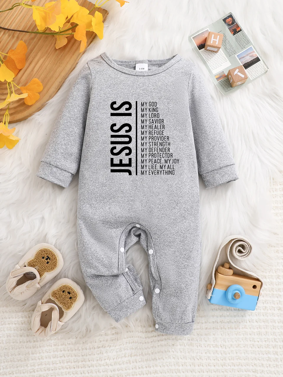 A baby long-sleeved onesie with interesting letter prints. It features a buttoned design for easy putting on and taking off, and