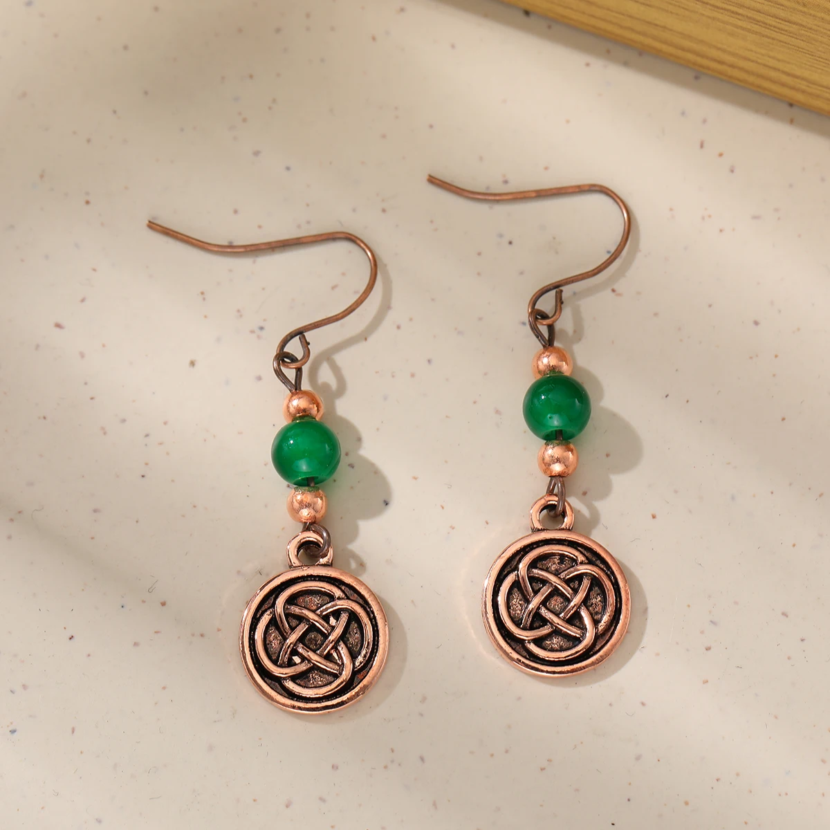 Ethnic-style artificial gemstone paired with Celtic knot pendant earrings for ladies. Perfect for parties and dates.