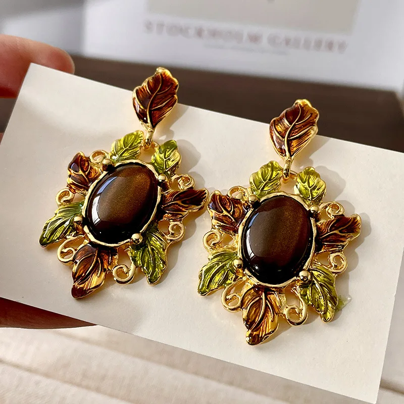 Colorful oil drop enamel gold leaf tiger eye stone glazed earrings surrounded by gold leaves