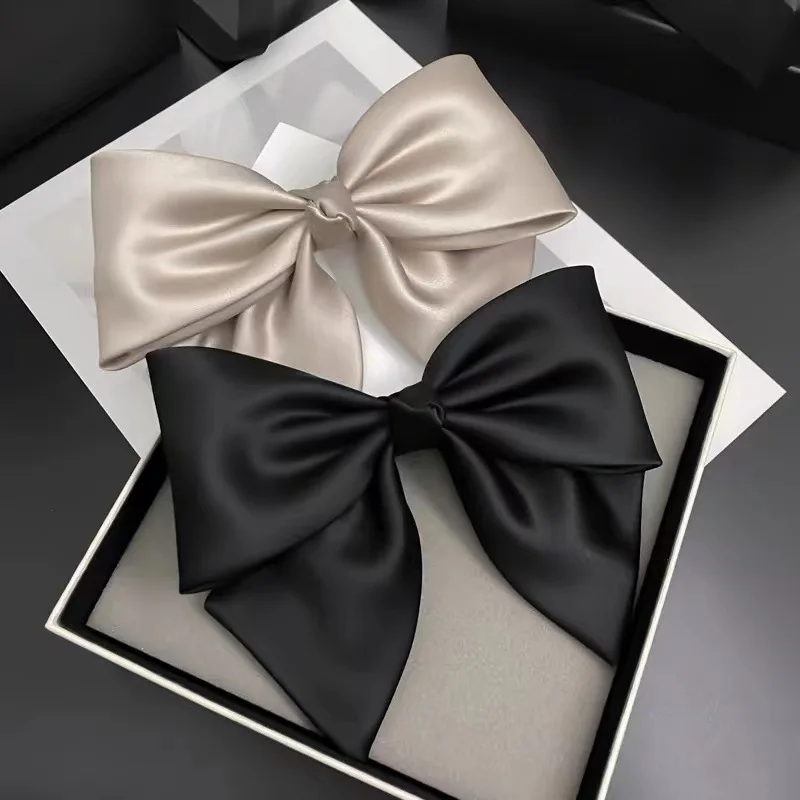 A high-end satin French hair accessory with a bow, black bow spring clip at the back of the head