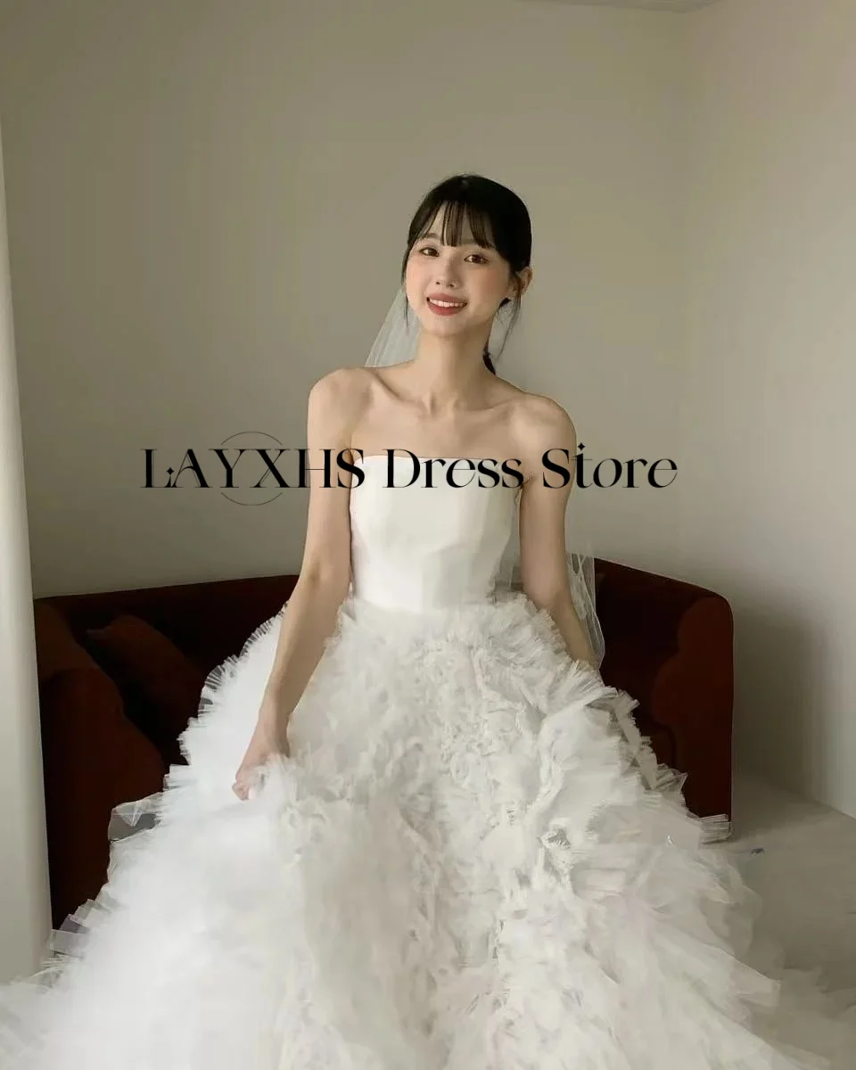 ชุดแต่งงานสีขาวแบบไร้สายหรูหรา ทรงเอไลน์ สไตล์เกาหลี-ญี่ปุ่น ผ้าซาตินและผ้าทูลล์ สำหรับถ่ายภาพ ชุดเจ้าสาวสั่งตัดได้ รุ่นใหม่ล่าสุดปี 2026