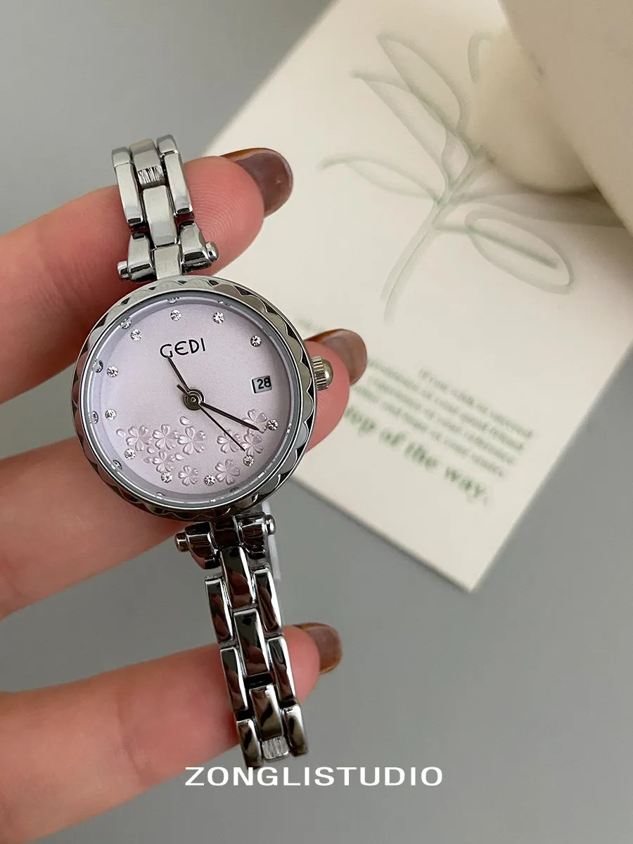 นาฬิกาข้อมือผู้หญิงสายเหล็กดีไซน์หรูหราใหม่ ดีไซน์กะทัดรัด ทันสมัย และน่าดึงดูดใจ นาฬิกาควอตซ์เรียบง่ายสำหรับนักเรียน พร้อมลวดลายดอกไม้