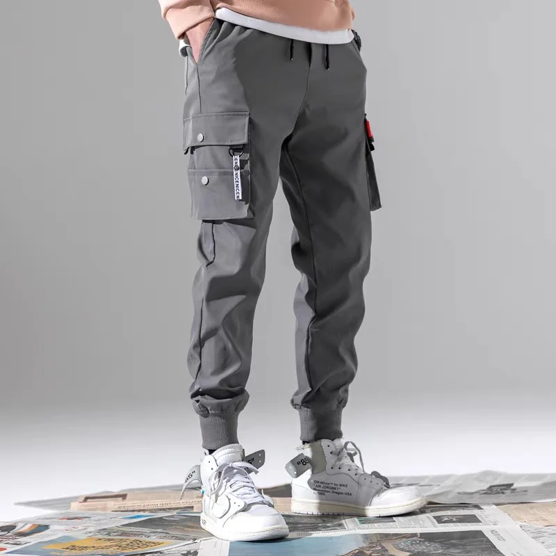 Pantaloni con cinturino da uomo nuovi estivi pantaloni Casual Hip Hop di colore popolare Multi tasca abbigliamento da strada pantaloni sportivi larghi attillati da uomo