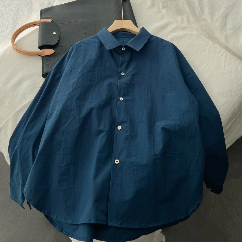 Luźna damska koszula bawełniana w kolorze niebieskim, wysoka ilość włókien, wyprana, w stylu lazy, długi rękaw, kołnierzyk, regularny krój, jednolity kolor.