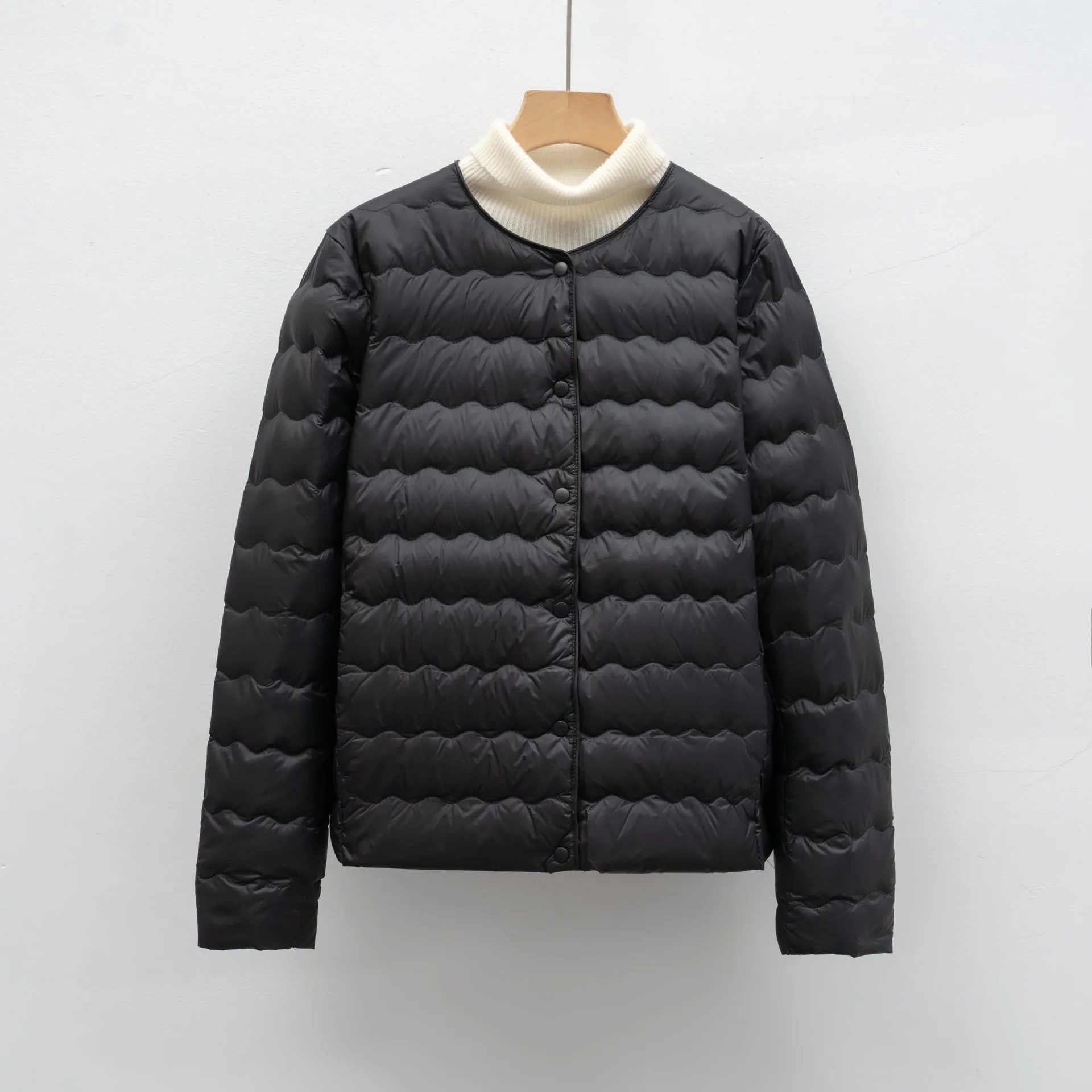 طبقة سفلية مموجة مخيطة مع حشوة 90% سفلية. سترة أنيقة ورقبة دائرية لدفء أنيق وخفيف الوزن تحت أي ملابس.