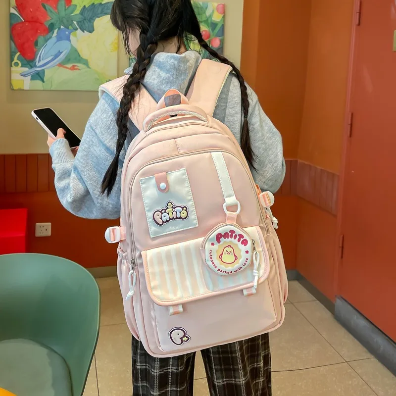 traveasy-ブランド-2026-新しい超かわいい学生スクールバッグ女の子用ナイロン漫画バッジ装飾カジュアルキャンパスデイパック女性