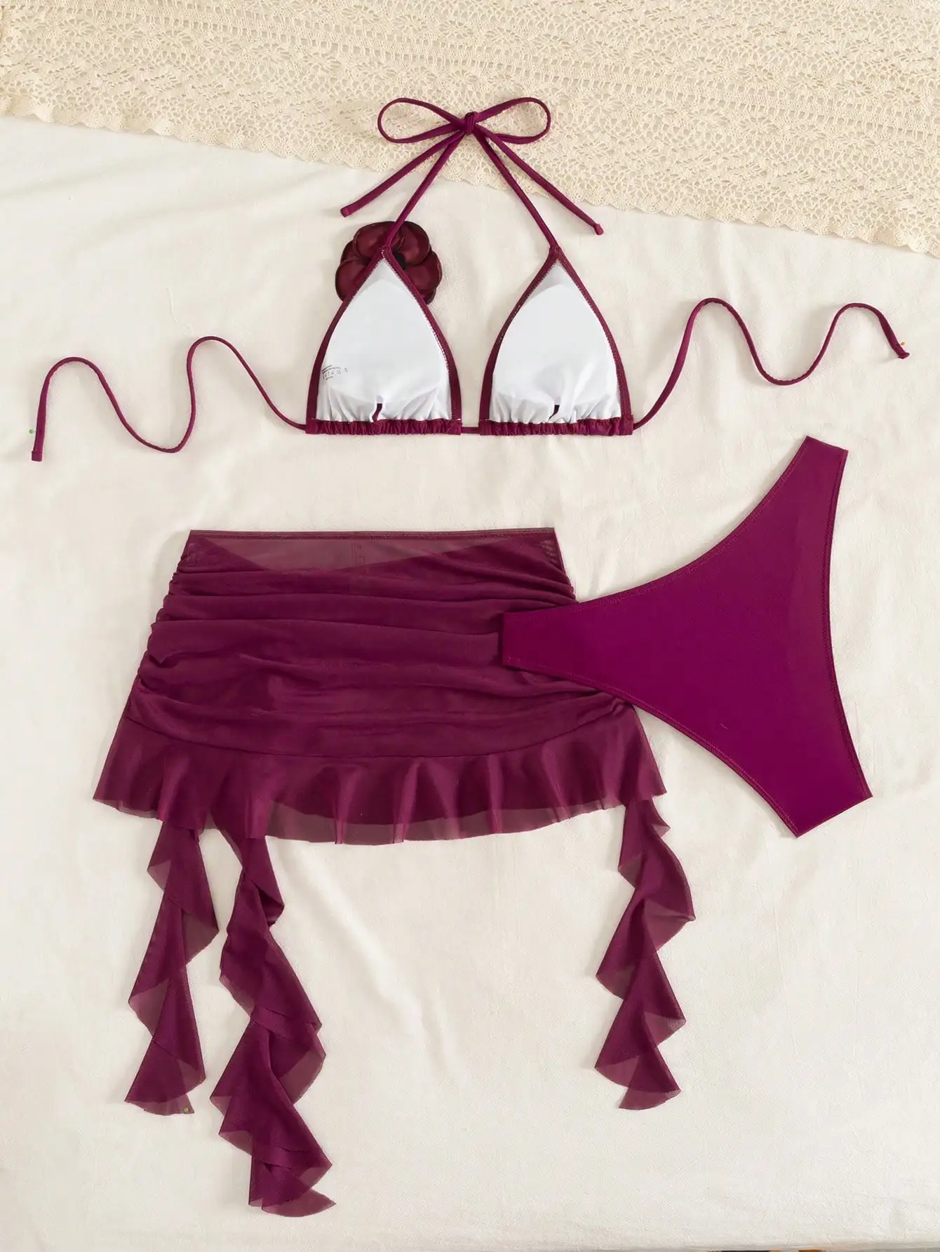 

Бордовое треугольное бикини с 3D-цветочным декором, прозрачной юбкой с рюшами и регулируемыми бретелями на шее.