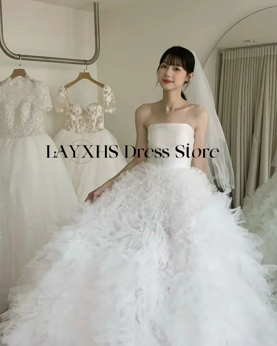 ชุดแต่งงานสีขาวแบบไร้สายหรูหรา ทรงเอไลน์ สไตล์เกาหลี-ญี่ปุ่น ผ้าซาตินและผ้าทูลล์ สำหรับถ่ายภาพ ชุดเจ้าสาวสั่งตัดได้ รุ่นใหม่ล่าสุดปี 2026