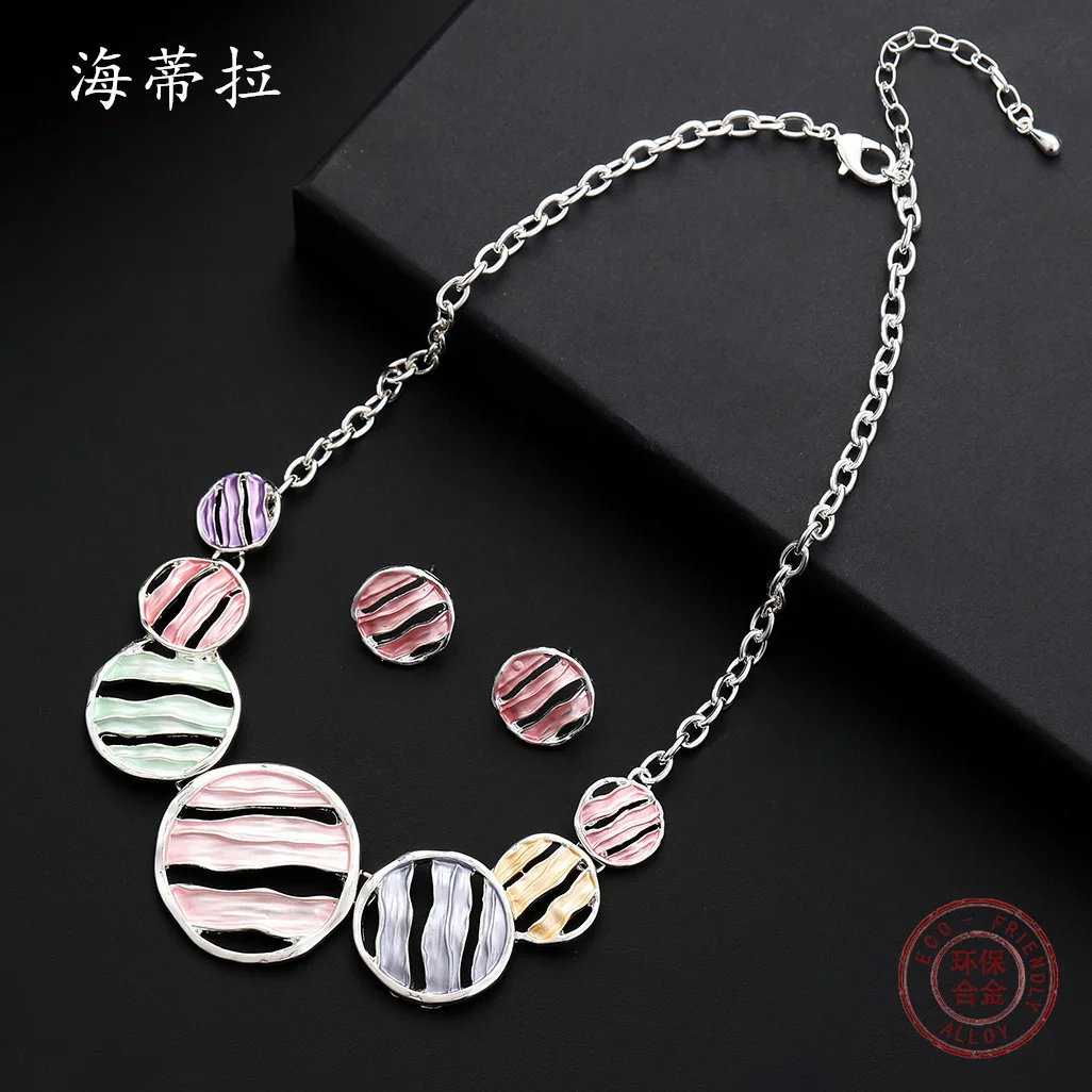 

Популярный набор украшений: круглые серьги-гвоздики и колье с нерегулярными полосками, модный универсальный женский комплект.