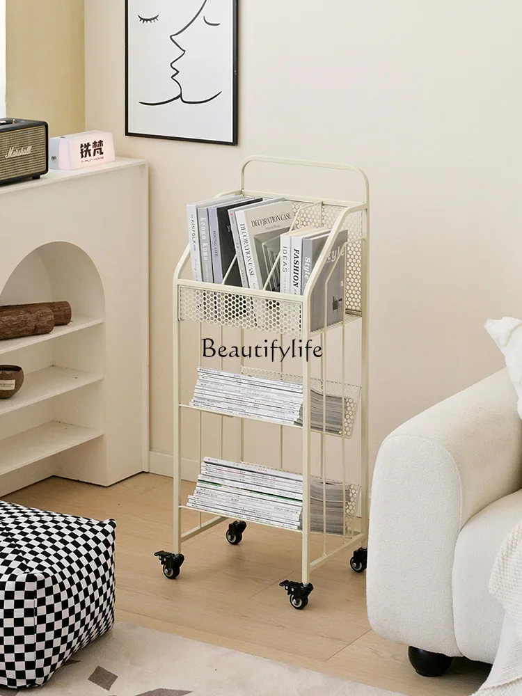 Removable shelf in living room, magazine rack with wheels for books next to desk