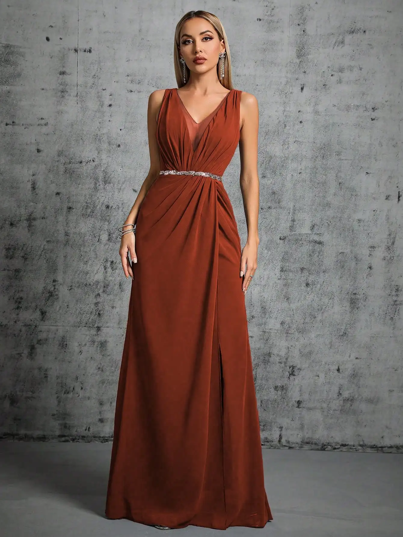 Ein langes Kleid mit tiefem V-Ausschnitt, silbernem Paillettengürtel, plissiertem Chiffon-Stil und doppelten Schlitzen