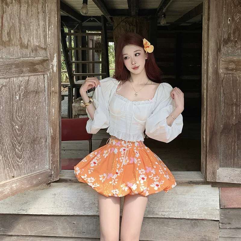 

Комплект: белая рубашка с рукавами-фонариками в стиле «Остров дофамина» и оранжевая пышная короткая юбка с цветочным принтом. Женская мода. Весна. Всесезонный.