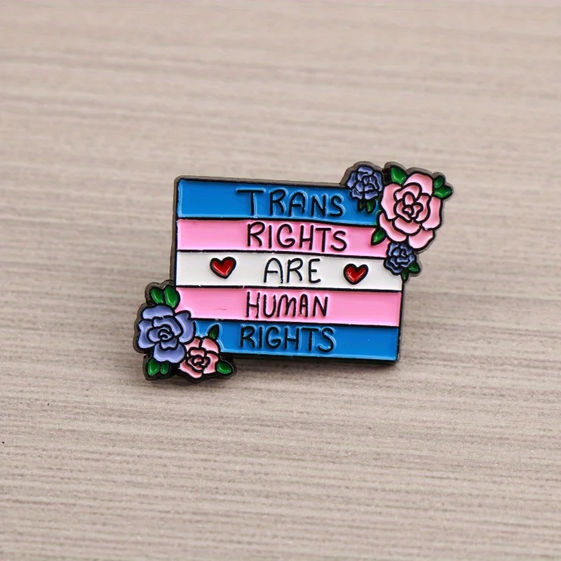 Trans Rights Advocacy Pin—Trans flag colors with “TRANS RIGHTS ARE HUMAN RIGHTS” and flowers, advocating gender equality.
